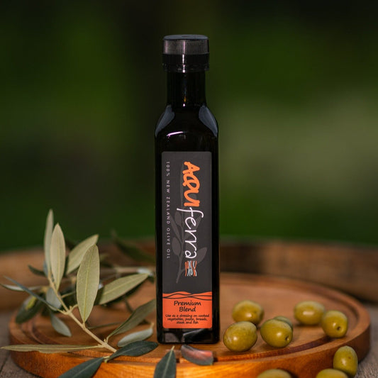 Aquiferra Premium Blend extra virgin olive oil bottle, mild to medium intensity with herbaceous flavors and a mild peppery finish, ideal for salads, cooked vegetables, pasta, bread, steak, and fish.